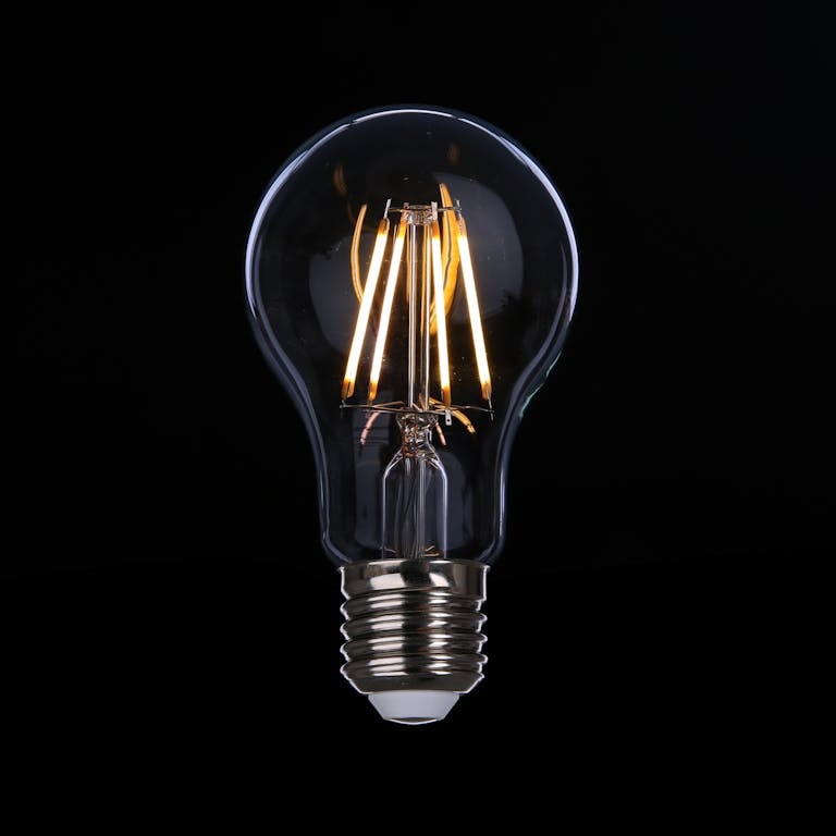 A detailed image of an illuminated LED light bulb against a dark backdrop, emphasizing energy efficiency.